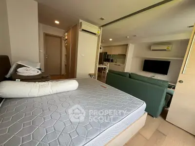 Modern studio apartment with open layout, featuring a cozy living area and compact kitchen.