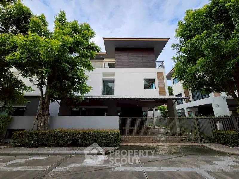 Modern two-story house with sleek design and lush greenery