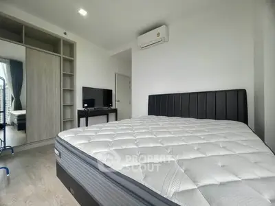 Modern bedroom with sleek design, featuring a comfortable bed, built-in wardrobe, and air conditioning.