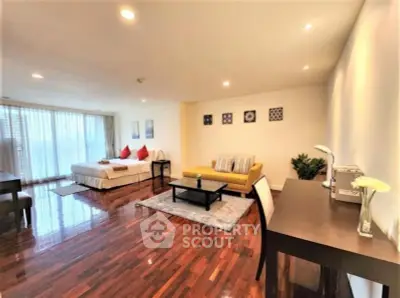 Spacious studio apartment with elegant wooden flooring and modern furnishings.