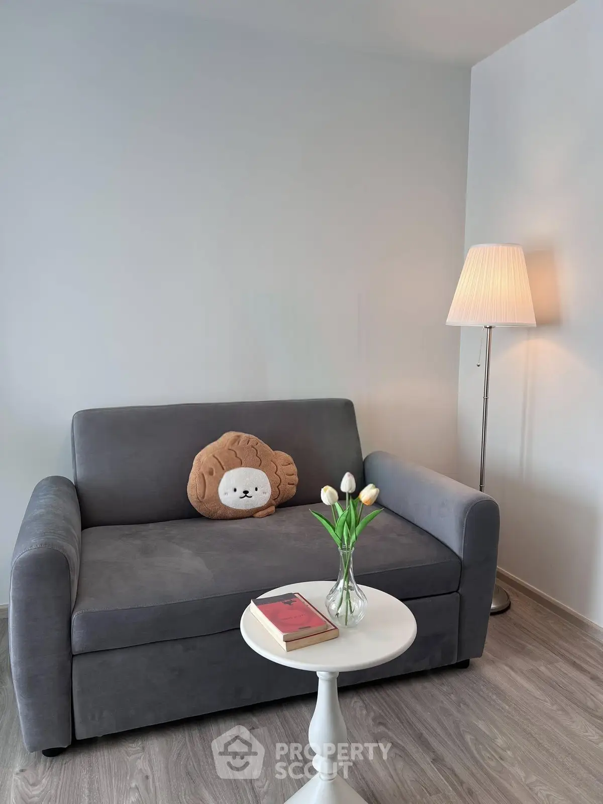 Cozy living room with plush sofa, stylish lamp, and elegant decor for a welcoming ambiance.