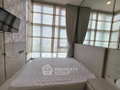 Modern bedroom with large windows and stylish decor in a high-rise apartment.