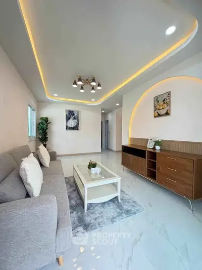 Modern living room with stylish lighting and elegant decor, featuring a cozy sofa and sleek furniture.