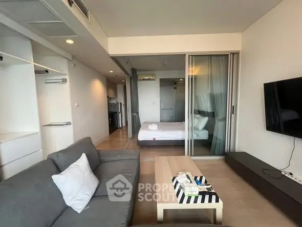 Modern open-plan living room with cozy bedroom and sleek decor