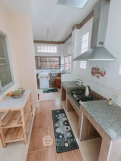 Spacious kitchen with modern appliances and open layout, featuring granite countertops and ample natural light.
