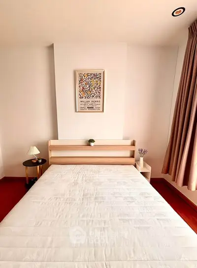 Modern bedroom with minimalist decor, featuring a wooden bed frame and stylish wall art, perfect for cozy living.