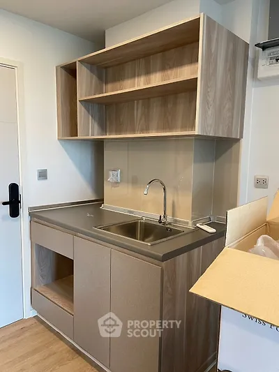 Modern kitchen with sleek cabinetry and stainless steel sink in a compact layout.