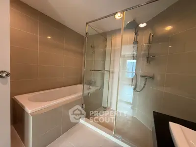 Modern bathroom with glass shower and bathtub in luxury apartment