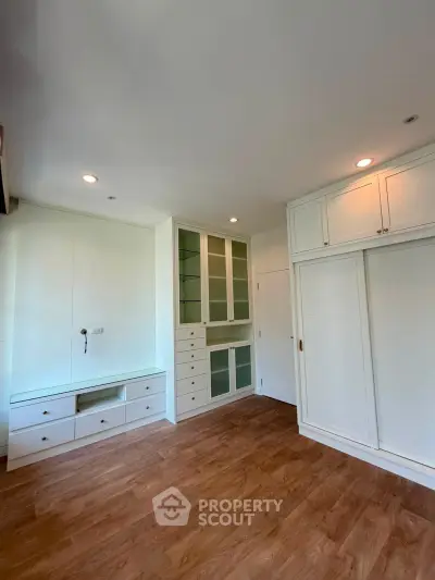 Spacious bedroom with built-in storage and wooden flooring, perfect for modern living.