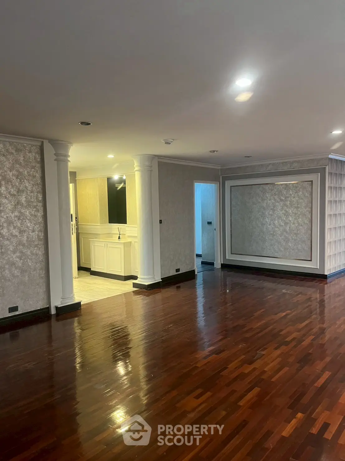 Spacious living room with elegant wooden flooring and classic wall design
