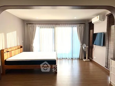 Spacious bedroom with modern decor and natural light