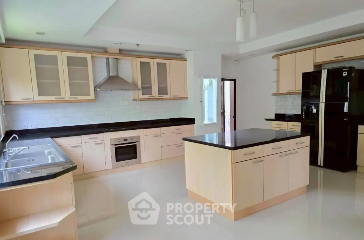 Spacious modern kitchen with sleek cabinetry and island in luxury home