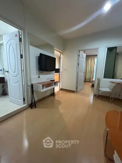 Modern apartment interior with wooden flooring and wall-mounted TV