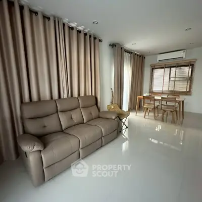 Spacious living room with modern furniture and elegant dining area, perfect for family gatherings.