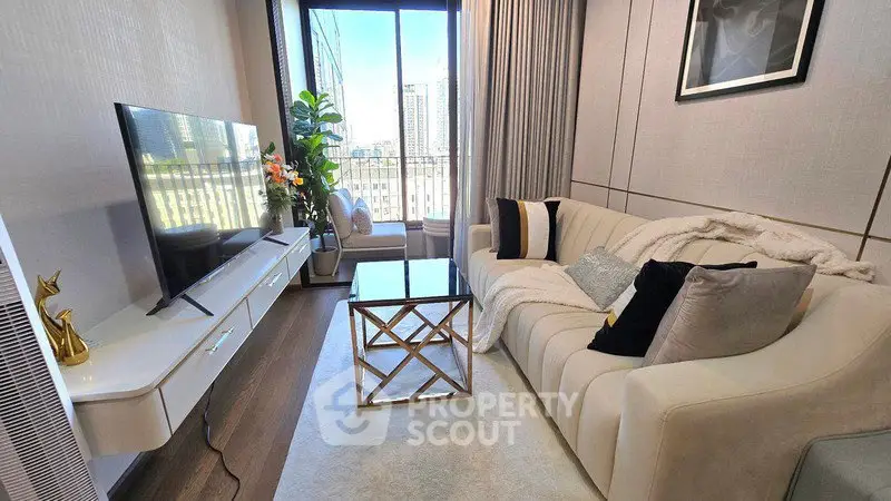 Luxurious living room with elegant decor and city view, featuring a plush sofa and modern TV setup.