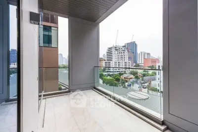 Spacious balcony with city view in modern high-rise apartment