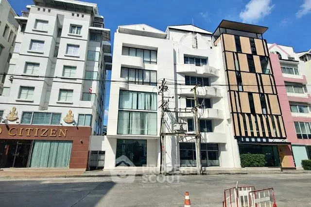 Modern urban apartment buildings with contemporary design and large windows under a clear blue sky.