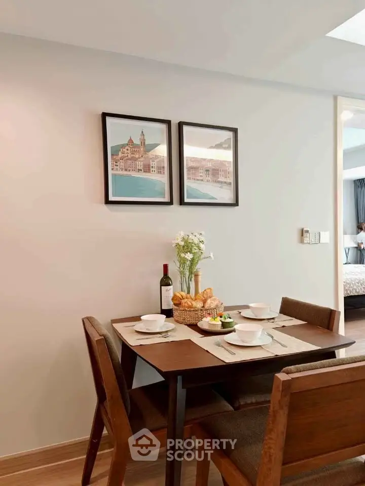Charming dining area with elegant table setting and wall art in modern apartment.