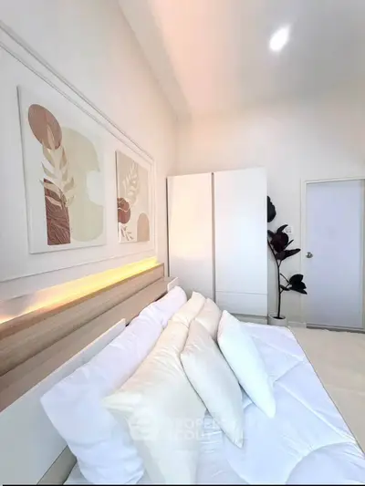Elegant bedroom with modern decor and soft lighting, featuring a cozy bed and stylish artwork.