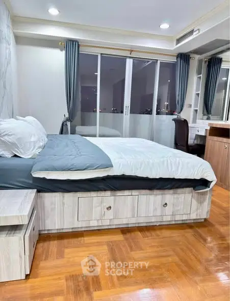 Spacious bedroom with modern decor and large window offering city views.