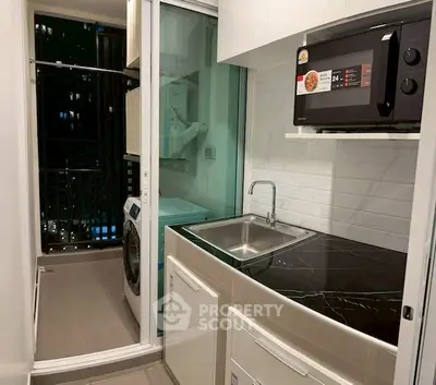 Modern compact kitchen with sleek appliances and city view