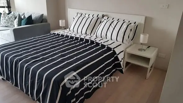 Modern bedroom with stylish striped bedding and cozy ambiance
