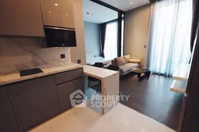 Modern open-layout kitchen and living room with sleek design and natural light.