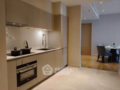 Modern kitchen with sleek cabinetry and dining area in luxury apartment
