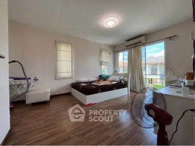 Spacious bedroom with large windows and wooden flooring in modern home