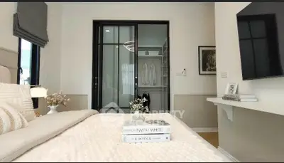 Elegant bedroom with walk-in closet and modern decor, featuring a cozy bed and stylish lighting.