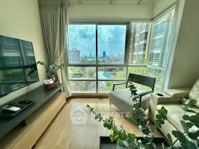 Modern living room with large windows offering stunning city view and abundant natural light.