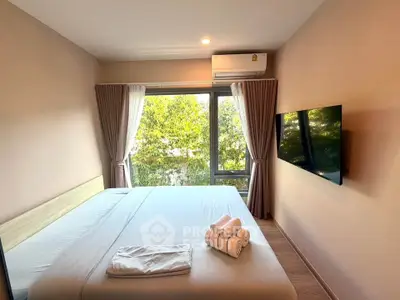 Cozy bedroom with large window and modern amenities, perfect for relaxation and comfort.