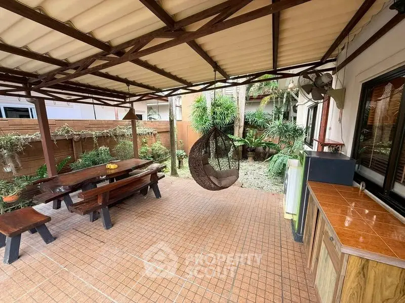 Charming outdoor patio with wooden furniture and lush garden view, perfect for relaxation and entertaining.