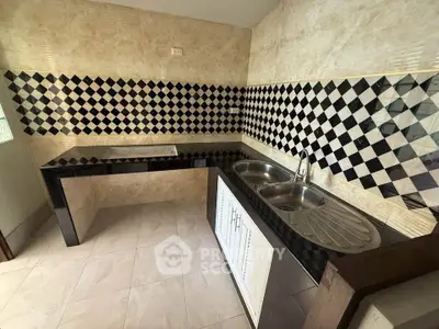 Modern kitchen with stylish black and white checkered backsplash and dual sink setup.