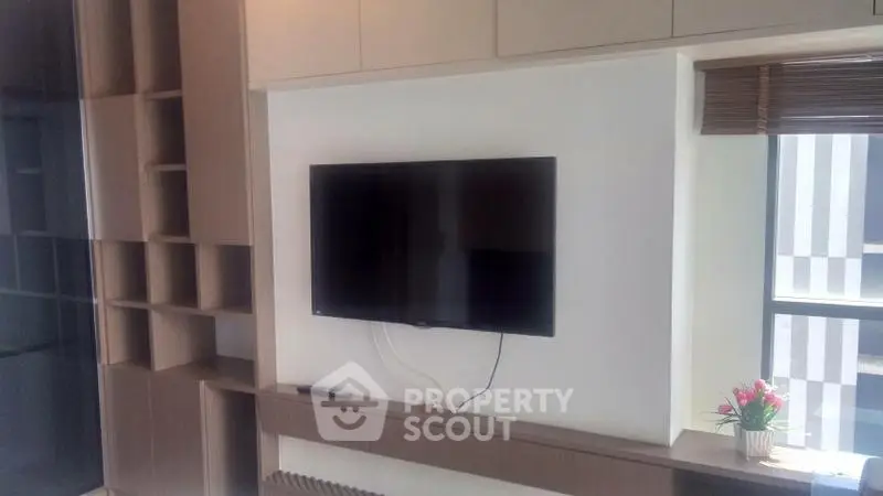 Modern living room with wall-mounted TV and stylish shelving