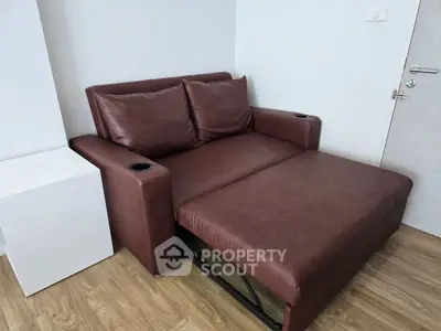 Modern brown leather sofa bed in a stylish living room corner, perfect for compact spaces.