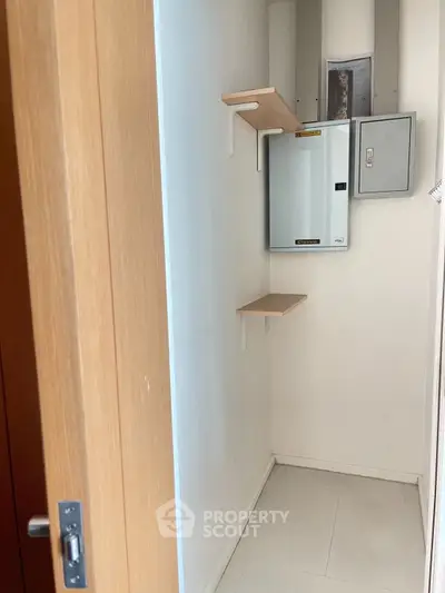 Compact storage room with shelves and electrical panel, ideal for organizing essentials.