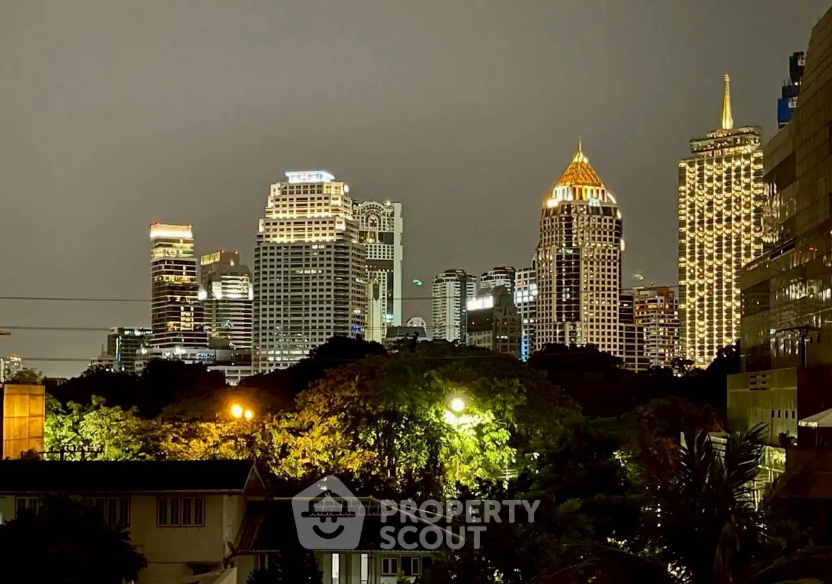 Stunning city skyline view with illuminated skyscrapers and lush greenery, perfect for urban living enthusiasts.