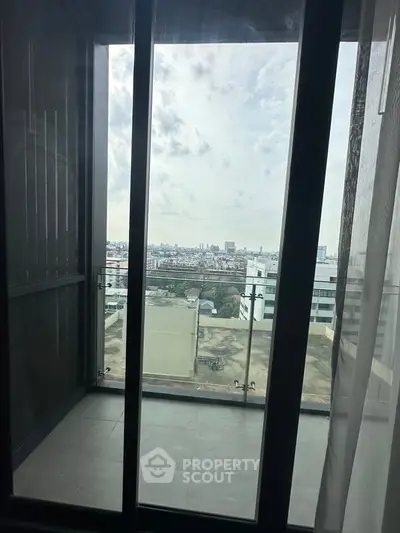 Stunning city view from a modern apartment balcony with glass railing.