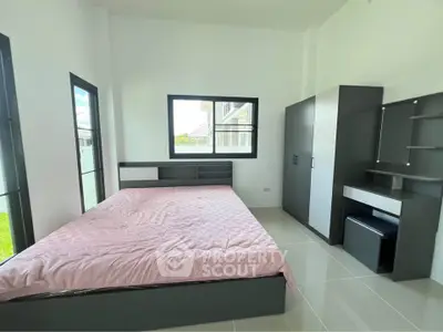 Modern bedroom with sleek furniture and large windows offering natural light.