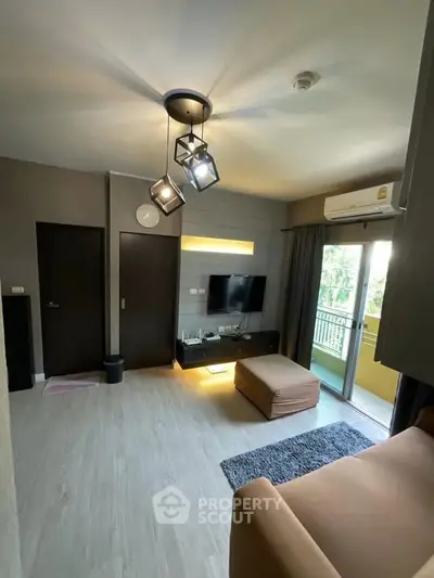 Modern living room with stylish lighting and balcony access in a cozy apartment.