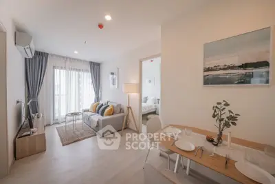 Modern open-plan living room with dining area and natural light, featuring stylish decor and cozy ambiance.