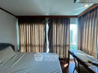 Cozy bedroom with city view, featuring large windows and elegant curtains, perfect for urban living.