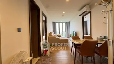 Spacious modern living room with dining area and cozy seating, featuring elegant decor and natural light.