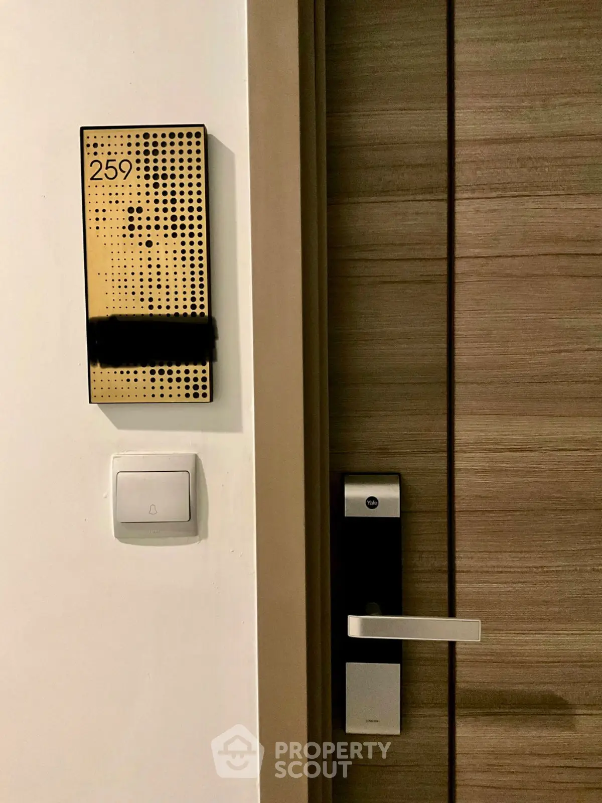 Modern apartment door with electronic lock and stylish room number 259.