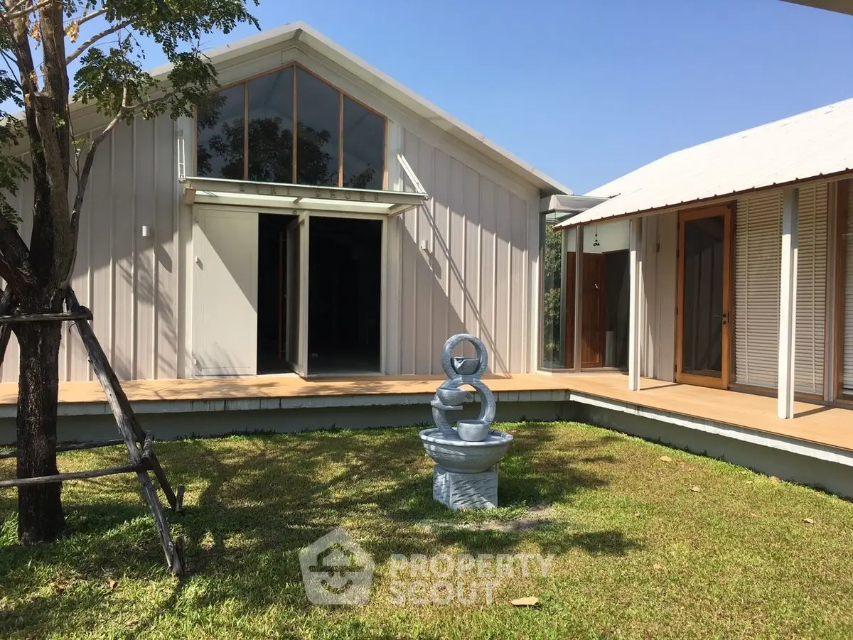 Charming modern house with large windows and lush green lawn, perfect for serene living.