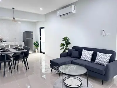Modern open-plan living room with sleek furniture and stylish kitchen in a contemporary apartment.