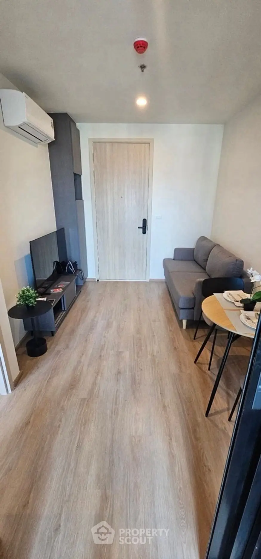 Modern living room with sleek furniture and wooden flooring, perfect for cozy urban living.