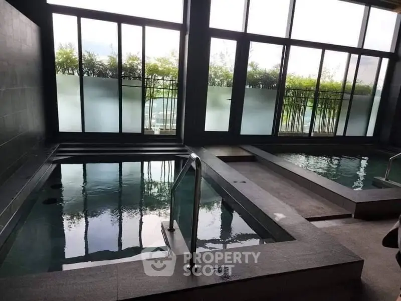 Luxurious indoor pool area with large windows and serene ambiance.