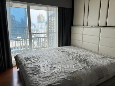 Modern bedroom with city view and large windows in high-rise apartment